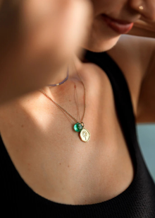 Close-up of a necklace with a pendant worn by a person