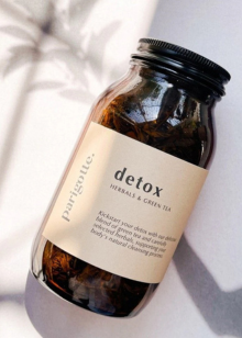 Bottle of 'detox' herbal tea with a label on a light background