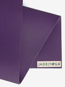 Jade Yoga mat close-up in purple, textured, durable, non-slip surface, eco-friendly yoga gear, side angle shot showing brand logo.