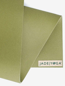 Jade Yoga green yoga mat close-up, textured non-slip surface, eco-friendly rubber material, angled side view with visible brand logo.
