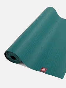 Teal yoga mat partially rolled with visible brand logo, textured non-slip surface, product shot from angled side view showing thickness and quality