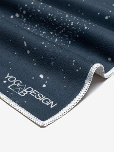 Yoga Design Lab navy blue yoga mat with white speckled pattern and white trim, close-up side view showing textured surface and logo.