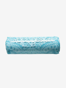Blue rolled YOGA DESIGN LAB premium hot yoga towel with pattern, side view on white background