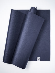 Navy blue textured yoga mats partially rolled, top view, on white background, eco-friendly material, exercise equipment, with visible brand logo