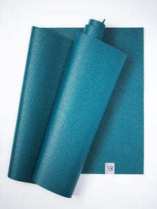 Teal yoga mat rolled and unrolled with non-slip texture shot from above on white background, visible brand logo