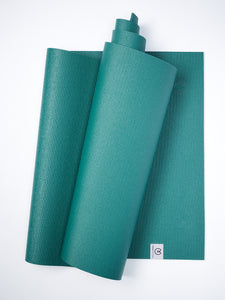 Teal yoga mat partially rolled with visible texture on white background, non-slip exercise mat, top view.