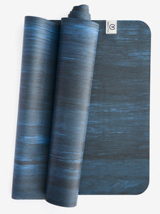 Blue textured yoga mat partially rolled, side view, eco-friendly material, non-slip surface, exercise equipment, wellness and fitness accessory