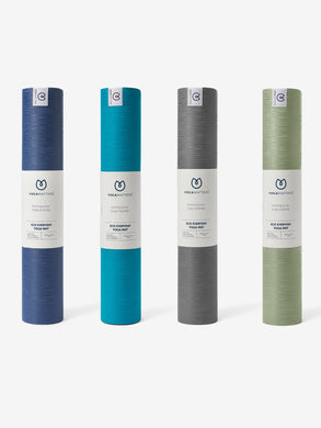 YogaMatters Eco Everyday Yoga Mat collection, front view of rolled mats in navy blue, teal, grey, and green colors on white background.