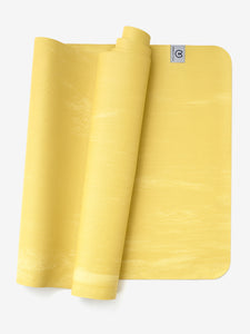 Yellow textured yoga mat partially rolled with visible brand logo, top view, non-slip exercise mat for fitness and meditation.