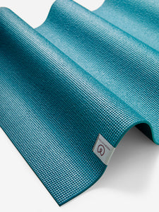 Textured teal yoga mat side view with visible Liforme brand logo, non-slip eco-friendly material, professional exercise mat for yoga practice