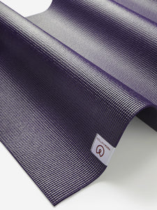 Purple textured Liforme yoga mat close-up side view with visible brand logo on label for eco-friendly exercise accessory.