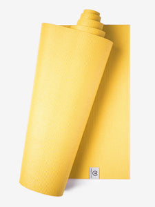 Yellow textured yoga mat partially rolled with visible logo, non-slip surface, premium exercise mat shot from the side on a white background.