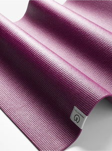 Close-up of a textured purple yoga mat by Liforme, side view with visible brand tag, eco-friendly and non-slip surface design.