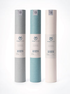 Yogamatters Eco Everyday Rise Yoga Mats, three rolled mats standing upright in grey, blue, and beige colors, isolated on white background.