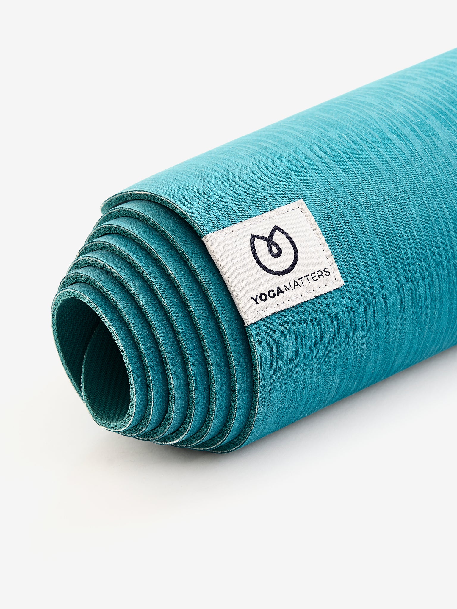 YogaMatters teal textured yoga mat rolled up, side angle view on a white background