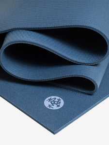 Navy blue textured yoga mat partially rolled with visible brand logo, close-up side view for fitness and meditation.