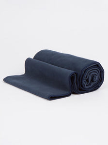 Navy blue yoga mat rolled up on white background, non-slip textured exercise mat, side view, fitness and wellness equipment