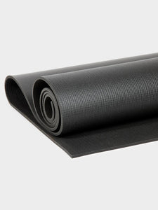Black yoga mat partially rolled up side view with textured surface detail visible.