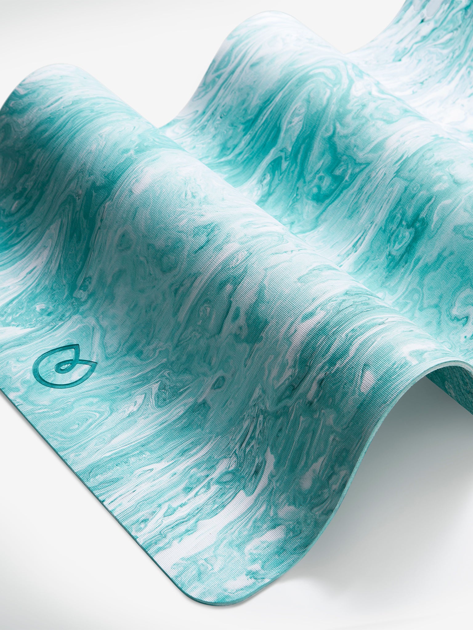 Close-up side shot of a turquoise marbled yoga mat with a visible logo, textured anti-slip surface, premium fitness and exercise accessory.