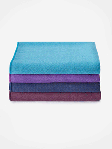 Stack of three rolled yoga mats from top view in blue, purple, and burgundy colors, textured non-slip surface, isolated on white background.