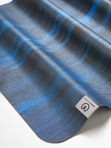 Lululemon yoga mat close-up texture from side angle, wavy blue and black design detailing, high-quality non-slip exercise mat for yoga and fitness enthusiasts