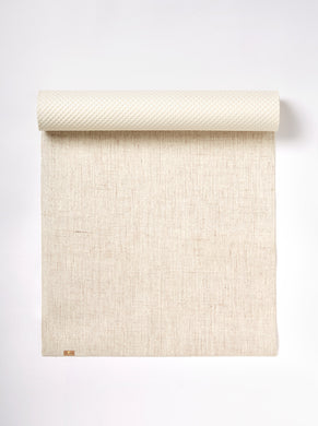 Beige textured yoga mat partially unrolled against a white background, neutral color palette, top-down view eco yoga jute mat