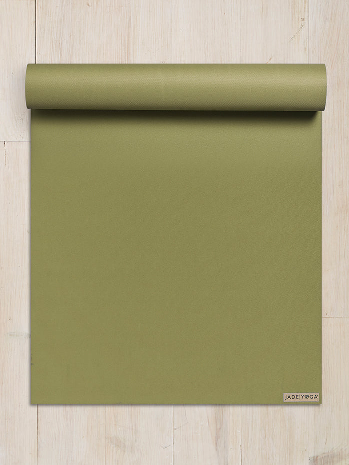 Jade Yoga mat rolled up at top, olive green color, eco-friendly natural rubber, professional yoga equipment, textured non-slip surface, fitness accessory, top-view shot on wooden floor background