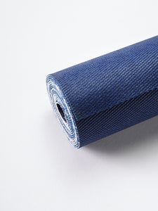 Navy blue rolled-up yoga mat side view on a white background