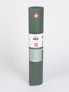 Manduka PRO yoga mat in sage green, rolled up, front view with logo and product information visible on packaging, high quality, non-slip, professional yoga equipment