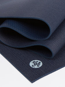 Navy blue textured yoga mat partially rolled, non-slip surface, eco-friendly material, top view with visible brand logo.