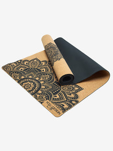 Partially unrolled black and tan yoga mat with intricate mandala design, side view, YOGA DESIGN brand visible.