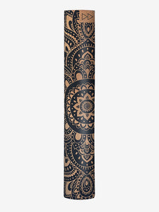 Black and gold patterned yoga mat with mandala design, rolled up side view on white background.
