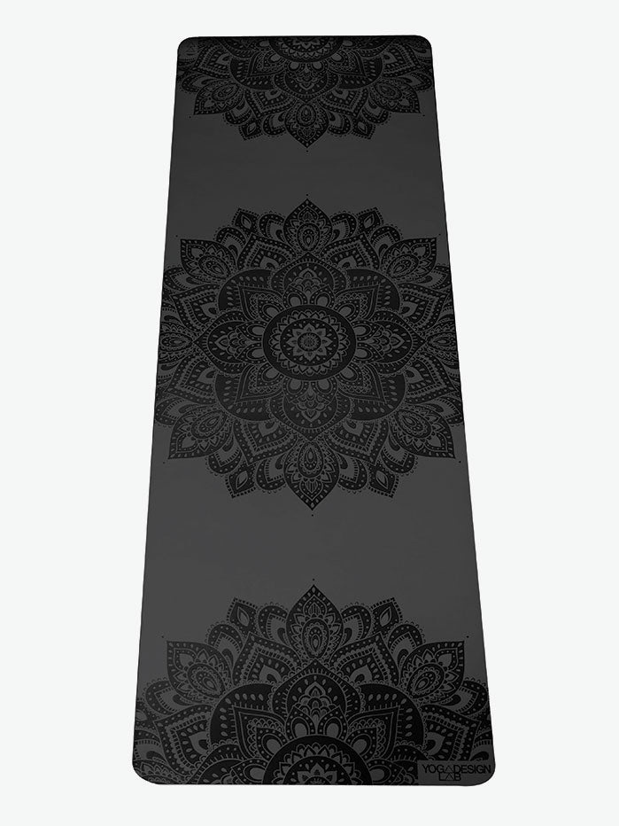 Black yoga mat with mandala pattern, YOGADESIGN brand, non-slip texture, eco-friendly material, top view.