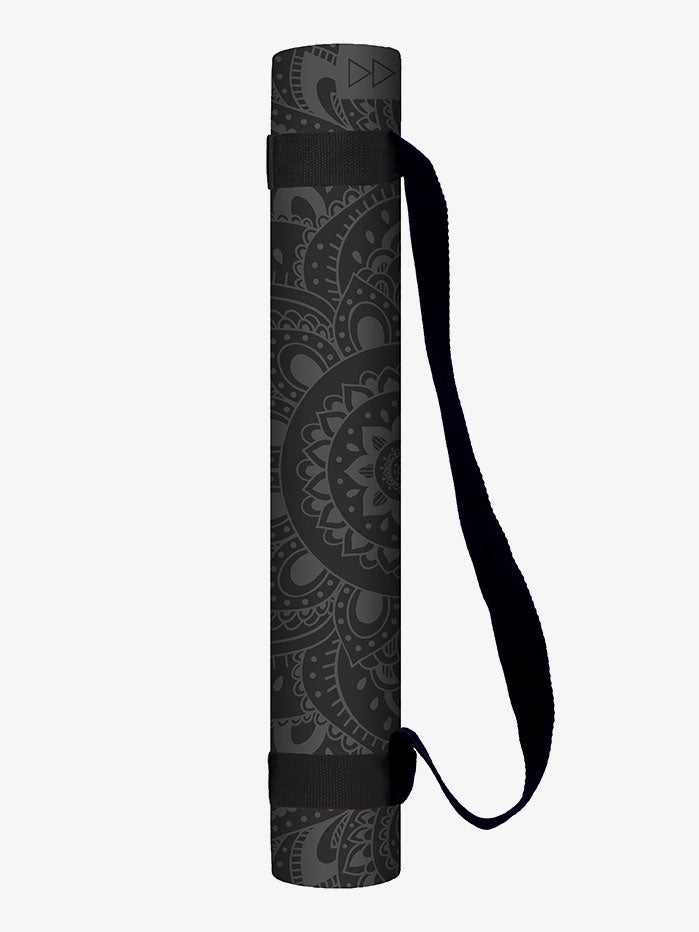 Rolled grey yoga mat with mandala pattern and carrying strap, side view.