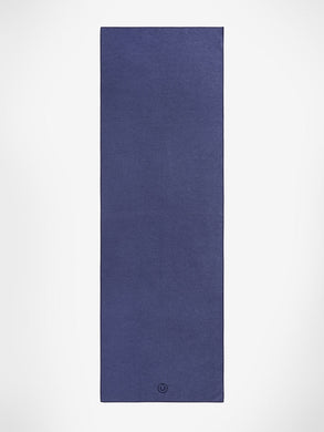 Navy blue yoga mat front view, textured non-slip surface, logo visible at bottom corner, thick cushioned exercise mat for yoga and pilates, studio style professional quality.