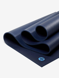 Navy blue textured yoga mat partially rolled from front view with visible logo.