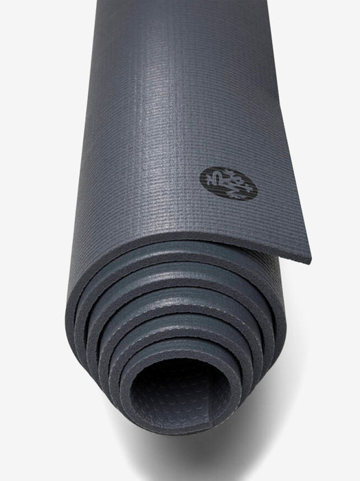 Close-up view of a rolled-up dark gray textured yoga mat with visible brand logo on the top right corner, photographed from a high angle against a white background.