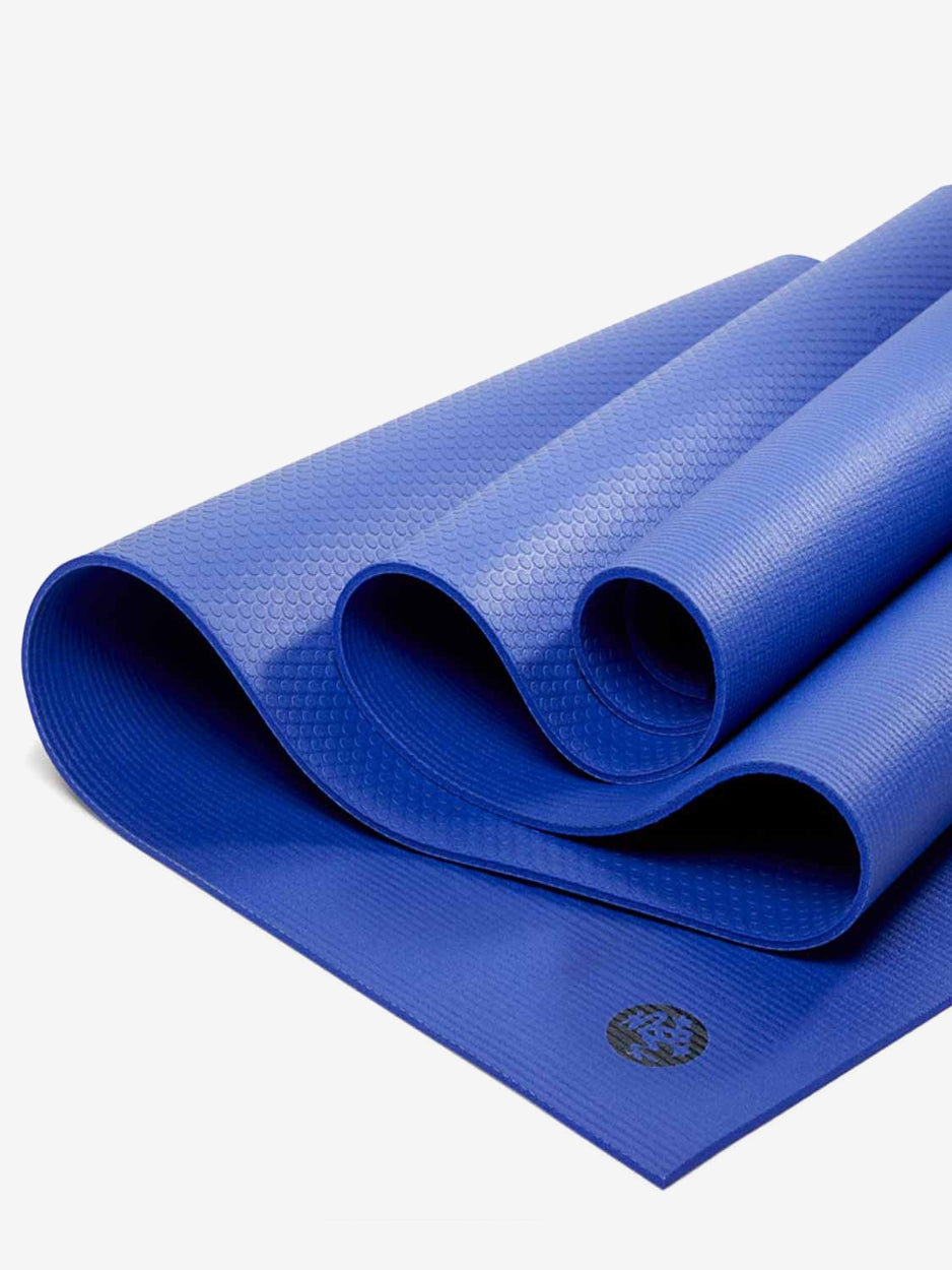 Blue textured yoga mat partially rolled showcasing grip surface and brand logo visible, shot from angled front perspective for online product visibility.