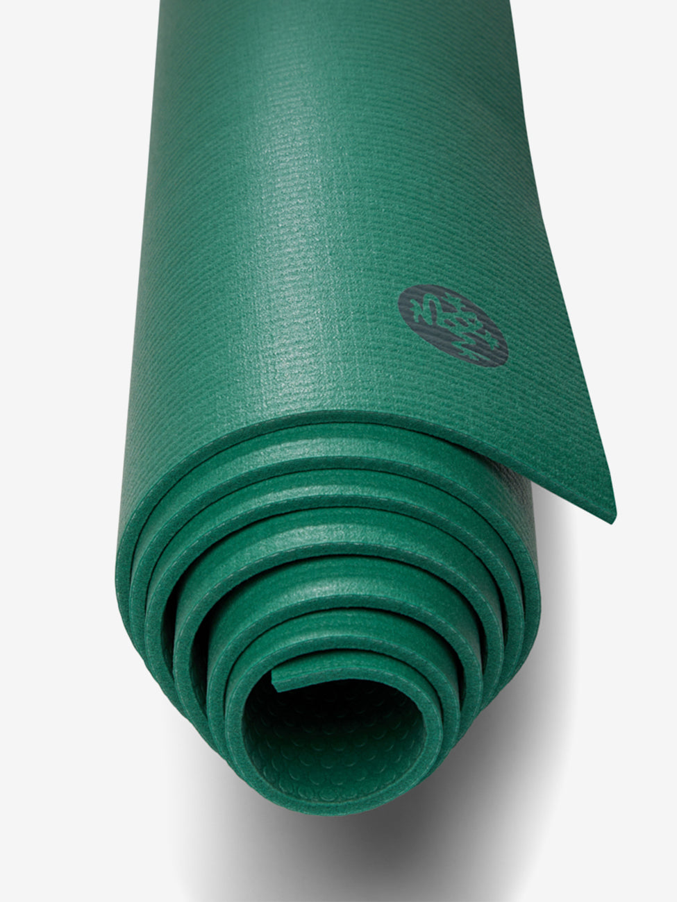 Green yoga mat partially unrolled with textured surface, side view, visible logo