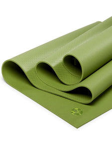 Green textured yoga mat partially unrolled on a white background, non-slip surface, eco-friendly material, side view detail showing thickness and texture, ideal for yoga and Pilates practice.