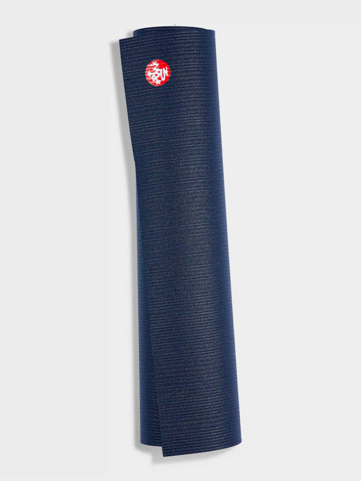 Navy blue rolled-up yoga mat with textured surface and visible red logo, shot from the side against a light background.