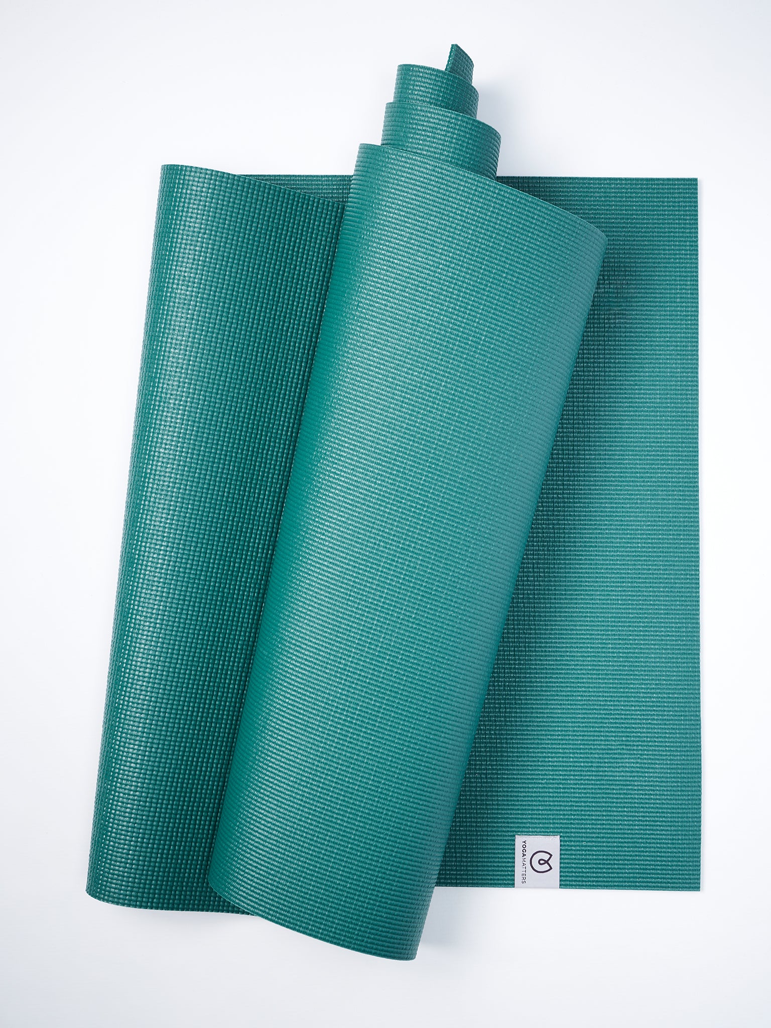 Teal yoga mat partially rolled with visible texture on white background, non-slip exercise mat, top view.