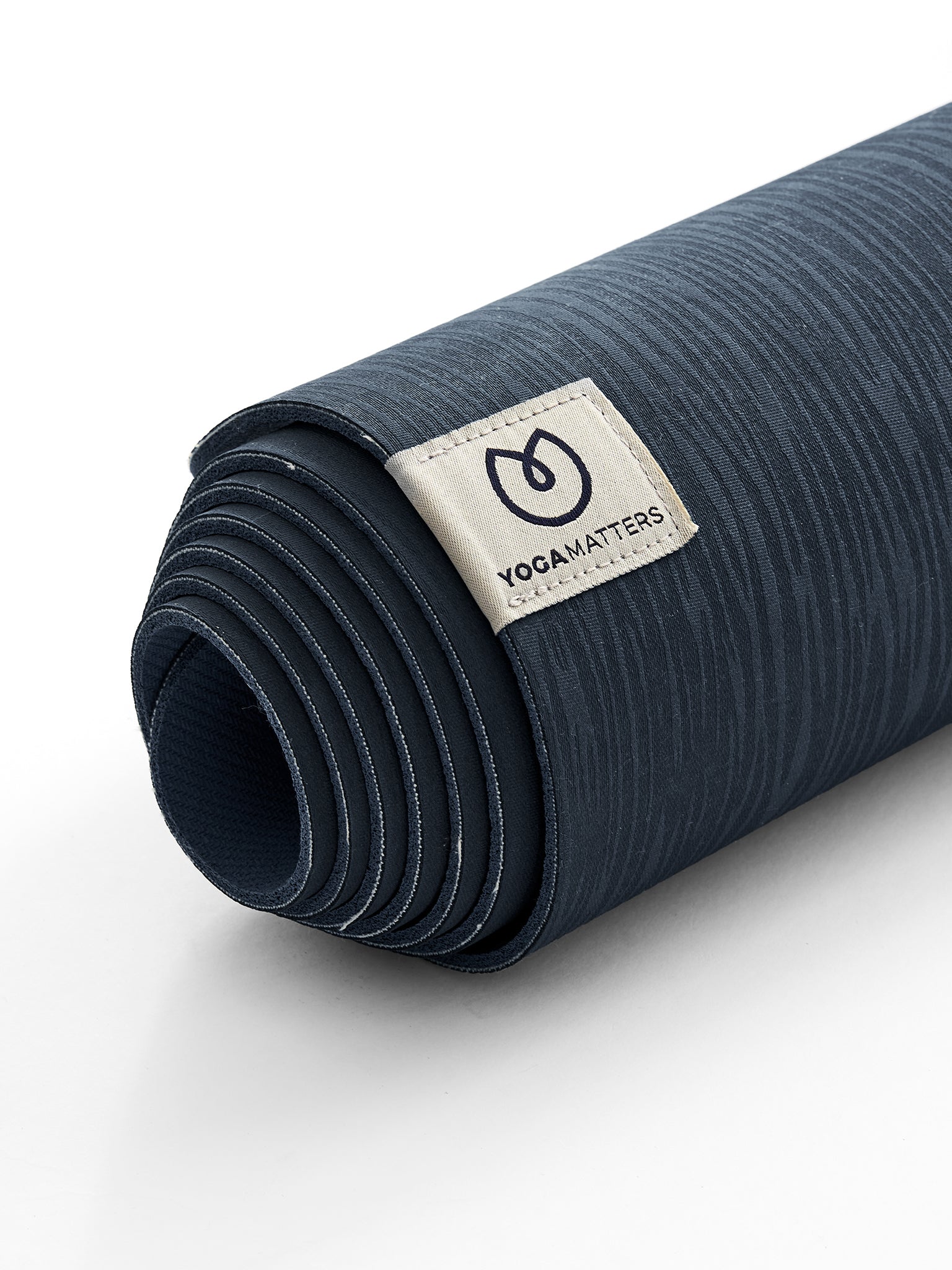 Yogamatters navy blue yoga mat rolled up front view with textured surface and brand label visible on white background.
