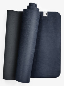 Navy blue textured yoga mat with visible brand logo, rolled and unrolled mats shot from front angle, non-slip exercise mat for fitness and meditation