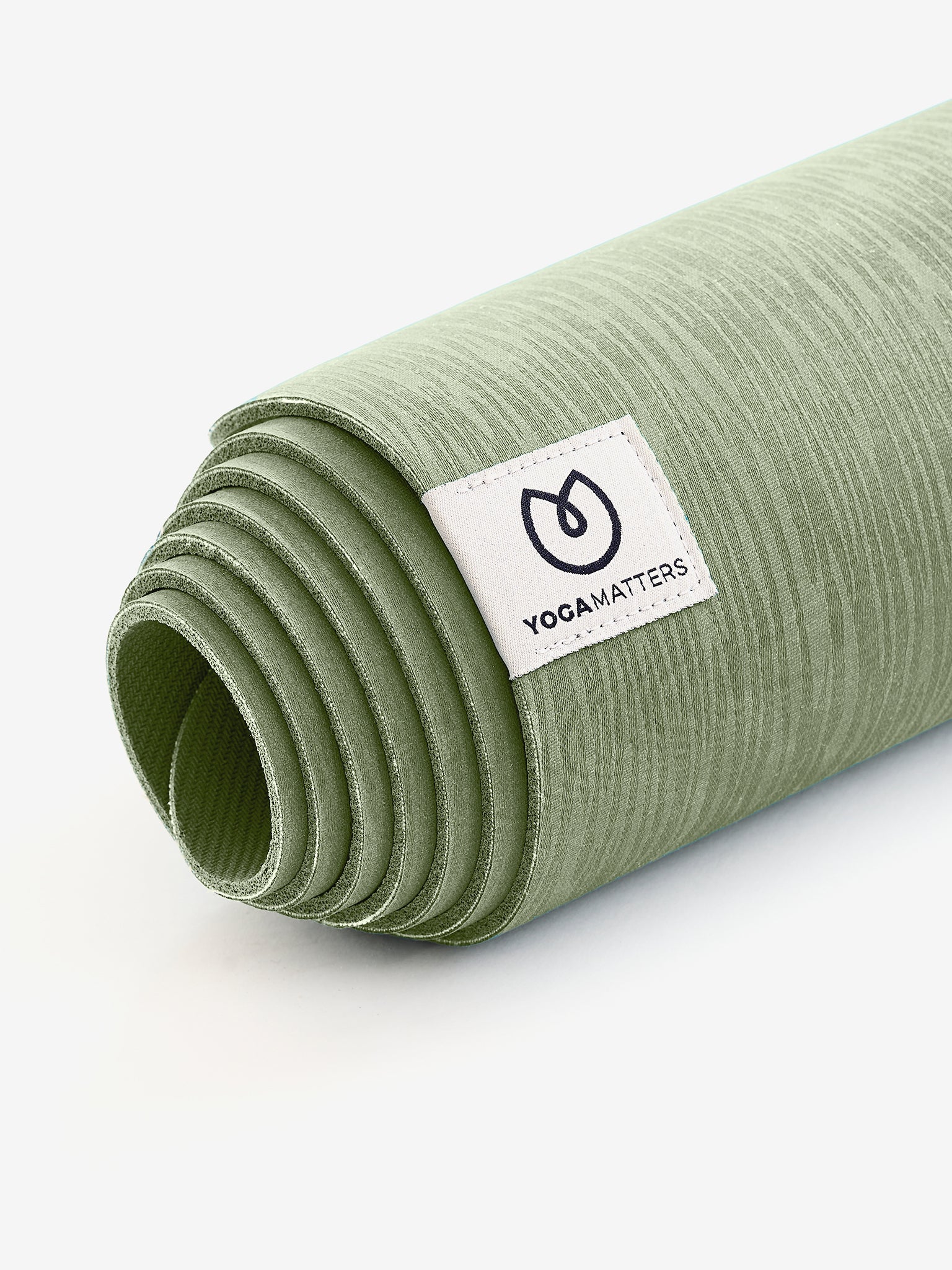 Yogamatters green textured yoga mat rolled up side view with visible brand tag on white background