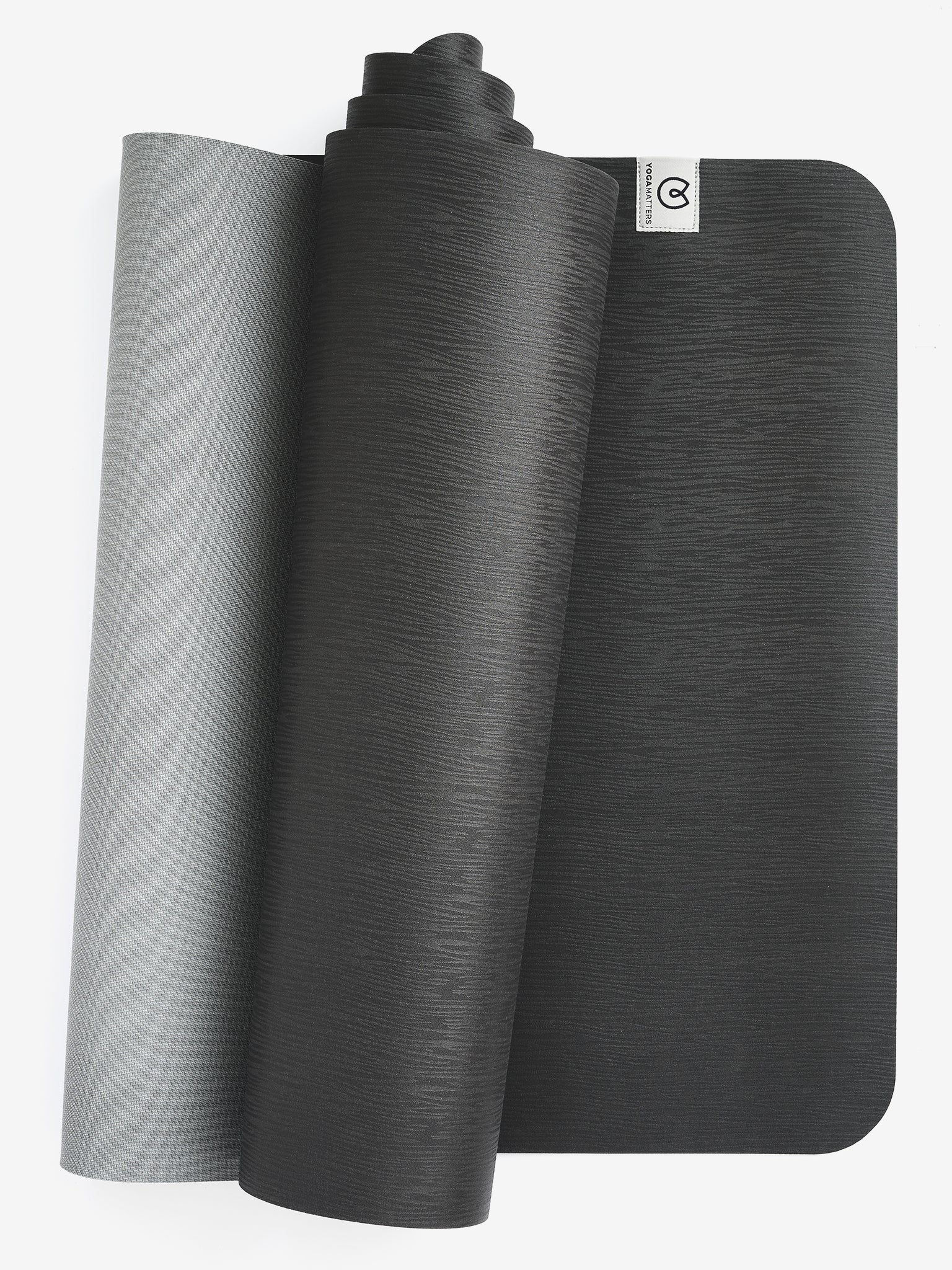 Two-tone gray premium yoga mat rolled halfway, textured non-slip surface, durable eco-friendly exercise mat, front-side view showing brand logo.