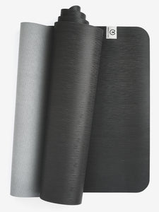 Dual-toned rolled yoga mat, gray and black textured, non-slip grip, eco-friendly material, side view, with visible logo.