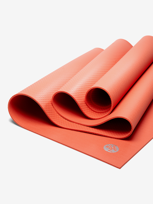 Coral red textured yoga mat partially rolled, non-slip surface, side view with visible brand logo