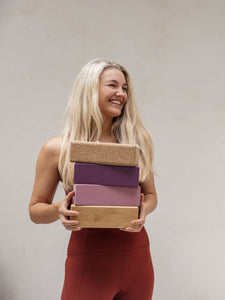 woman holding cork bamboo colour yoga brick blocks 