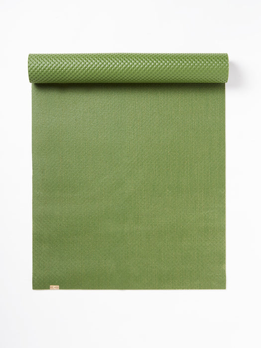Green textured yoga mat with visible brand tag on lower right corner